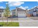 Exterior shot of home with gray siding, a two-car garage, and desert landscaping at 9314 Biscay St, Commerce City, CO 80022