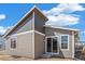 Back exterior featuring gray siding, a sliding glass door, and a corner lot at 9314 Biscay St, Commerce City, CO 80022