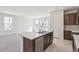 Kitchen island with double sink, stainless dishwasher, and open to the living area at 9314 Biscay St, Commerce City, CO 80022