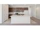 An open kitchen with a central island, stainless appliances, and a view to the carpeted stairs at 9314 Biscay St, Commerce City, CO 80022