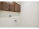 Functional laundry area with upper cabinets and utility connections for modern conveniences at 9314 Biscay St, Commerce City, CO 80022
