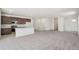 Spacious open-concept area with plush carpet and a kitchen with an island at 9314 Biscay St, Commerce City, CO 80022
