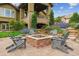 Serene backyard featuring a brick fire pit, patio seating, and lush landscaping at 4651 Sonado Pl, Parker, CO 80134