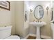 Charming half bathroom features a pedestal sink, decorative mirror, and warm lighting at 4651 Sonado Pl, Parker, CO 80134