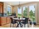 Bright breakfast nook with a custom round table, wooden cabinets, and views of the lush landscape at 4651 Sonado Pl, Parker, CO 80134