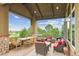 Charming covered porch with stone columns, outdoor seating, and a view of the landscaped backyard at 4651 Sonado Pl, Parker, CO 80134