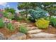 Beautifully landscaped garden with stone steps, colorful flowers, and mature trees at 4651 Sonado Pl, Parker, CO 80134