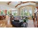 Open-concept living room with hardwood floors, beamed ceilings, and large windows at 4651 Sonado Pl, Parker, CO 80134