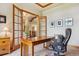 Home office featuring a spacious desk, elegant chair, and decorative glass paneled doors at 4651 Sonado Pl, Parker, CO 80134