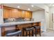 Basement wet bar with wooden cabinetry, tiled backsplash, and seating for entertaining at 4651 Sonado Pl, Parker, CO 80134