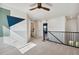 Hallway featuring carpeted floors, modern railing, and colorful geometric wall decor at 17692 Olive St, Broomfield, CO 80023