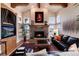 Spacious living room featuring a stone fireplace, hardwood floors, and large windows at 8002 Galileo Way, Littleton, CO 80125