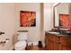 Elegant powder room with dark wood vanity and decorative mirror at 8002 Galileo Way, Littleton, CO 80125