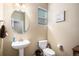 Bathroom featuring a pedestal sink, round mirror, and a neutral color scheme, creating a clean and simple space at 14058 Elizabeth St, Thornton, CO 80602