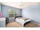 Bedroom featuring light blue walls, a ceiling fan, and a window, creating a serene and cozy space at 14058 Elizabeth St, Thornton, CO 80602