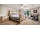 Main bedroom featuring a tray ceiling, carpet, upholstered bed, and a window, creating a comfortable retreat at 14058 Elizabeth St, Thornton, CO 80602