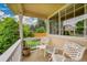 Cozy porch with two white chairs, small round table, and view of the green lawn and surrounding trees at 13112 Summit Grove Pkwy, Thornton, CO 80241