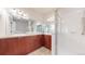 Bright bathroom with dual sinks, cabinets, a large mirror, and a glass shower at 3985 W 104Th Dr # E, Westminster, CO 80031