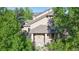 Charming exterior view of the home featuring stone accents, a welcoming front porch, and mature trees at 3985 W 104Th Dr # E, Westminster, CO 80031