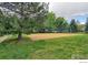 Sandy community volleyball court surrounded by a grass lawn and mature trees at 3985 W 104Th Dr # E, Westminster, CO 80031