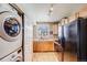 Galley kitchen featuring wood cabinets, stainless steel sink, and full size appliances at 17282 E Tennessee Dr, Aurora, CO 80017