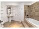 Charming bathroom featuring a pedestal sink, tiled shower and tub combo, and built in wall shelves at 2646 S Madison St, Denver, CO 80210