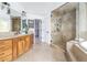Bright bathroom featuring a spacious shower with tile surround, soaking tub, and double vanity at 2646 S Madison St, Denver, CO 80210