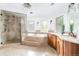 Luxurious bathroom with a soaking tub, glass shower, and natural stone accents at 2646 S Madison St, Denver, CO 80210