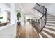 Bright foyer with hardwood floors and curved staircase with black iron railings at 2646 S Madison St, Denver, CO 80210