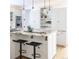 Bright kitchen features white cabinets, granite counters, stainless steel appliances, and a center island with pendant lighting at 2646 S Madison St, Denver, CO 80210