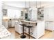Bright kitchen features white cabinets, granite counters, stainless steel appliances, and a center island with pendant lighting at 2646 S Madison St, Denver, CO 80210
