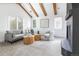 Comfortable living room boasts a modern fireplace, bright windows, wood beam ceiling, and ample seating for relaxation and entertainment at 2646 S Madison St, Denver, CO 80210