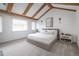 Spacious primary bedroom features a tray ceiling with wood beams and two large windows at 2646 S Madison St, Denver, CO 80210