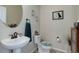 Charming powder room featuring a pedestal sink, round mirror, and decorative accents at 15088 Verbena St, Thornton, CO 80602