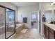 Bathroom with soaking tub, a glass shower, and stylish vanity with plenty of light at 15088 Verbena St, Thornton, CO 80602