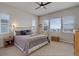 Bright bedroom featuring a brass bed frame, neutral walls, and natural light from multiple windows at 15088 Verbena St, Thornton, CO 80602