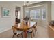 Inviting dining room with wood table, six chairs, buffet, and bay windows at 15088 Verbena St, Thornton, CO 80602