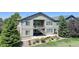 Exterior view of a home with a private balcony and staircase surrounded by lush greenery at 15088 Verbena St, Thornton, CO 80602