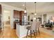 Kitchen island with breakfast bar and stainless steel appliances open to living area at 15088 Verbena St, Thornton, CO 80602