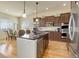 Open concept kitchen with stainless appliances, center island, and hardwood flooring at 15088 Verbena St, Thornton, CO 80602