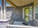 Welcoming porch with stone accents and stylish front door with glass inserts at 15088 Verbena St, Thornton, CO 80602