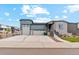 Charming home with a gray exterior, well-manicured lawn, a stone facade, and a spacious driveway at 5385 Trails Edge Ln, Castle Rock, CO 80104