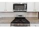 Modern Kitchen featuring stainless steel appliances and a gas cooktop, set against white cabinets and granite counters at 5385 Trails Edge Ln, Castle Rock, CO 80104
