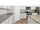 Modern kitchen with white cabinetry, granite countertops, and stainless steel appliances, including a gas range at 5385 Trails Edge Ln, Castle Rock, CO 80104