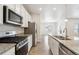 Stainless appliances and granite counters accent this bright kitchen, featuring an island and views of the living area at 5385 Trails Edge Ln, Castle Rock, CO 80104