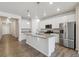 Bright kitchen features white cabinets, stainless steel appliances, granite counters, and a large island at 5385 Trails Edge Ln, Castle Rock, CO 80104