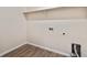 Bright laundry area featuring wood-look flooring, utility connections and shelf space at 5385 Trails Edge Ln, Castle Rock, CO 80104