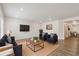 Open-concept living room with modern furniture, including couches, chairs, and a large-screen TV at 5385 Trails Edge Ln, Castle Rock, CO 80104