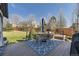 Outdoor deck with a dining set, grill, and hot tub surrounded by lush green grass at 7378 Geode Ct, Castle Rock, CO 80108