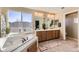 Bright bathroom with dual sinks, soaking tub and a large window showcasing the outdoor scenery at 7378 Geode Ct, Castle Rock, CO 80108